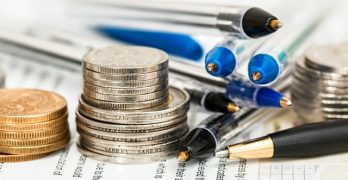 stacked coins with pens